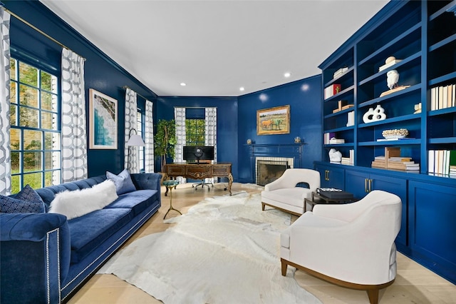 living area with light wood-type flooring and crown molding