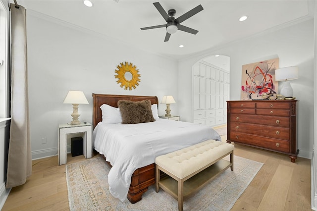 bedroom featuring ornamental molding, a closet, light wood-type flooring, and ceiling fan