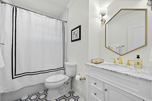 bathroom with toilet, vanity, tile patterned floors, and crown molding