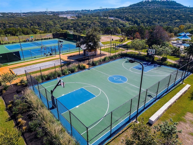 view of basketball court with tennis court and a mountain view