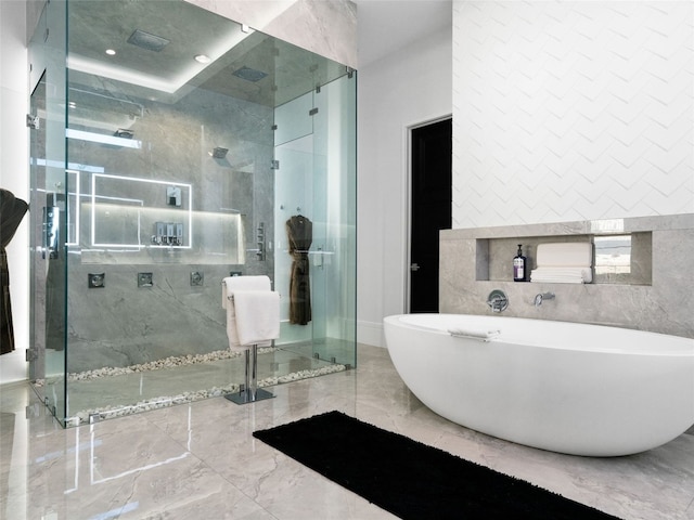 bathroom with shower with separate bathtub and tile walls