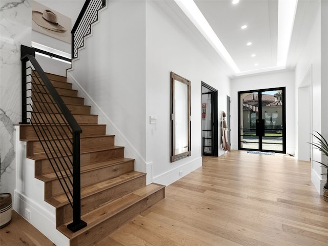 foyer with french doors and light hardwood / wood-style floors