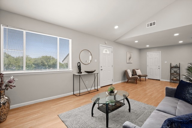 living room featuring light wood-type flooring and vaulted ceiling