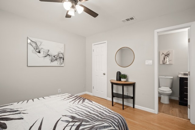 bedroom with light hardwood / wood-style floors, ceiling fan, and ensuite bathroom