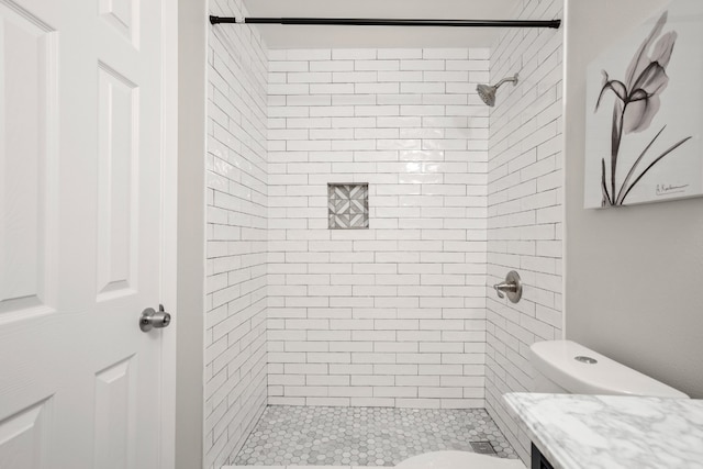 bathroom featuring toilet and a tile shower