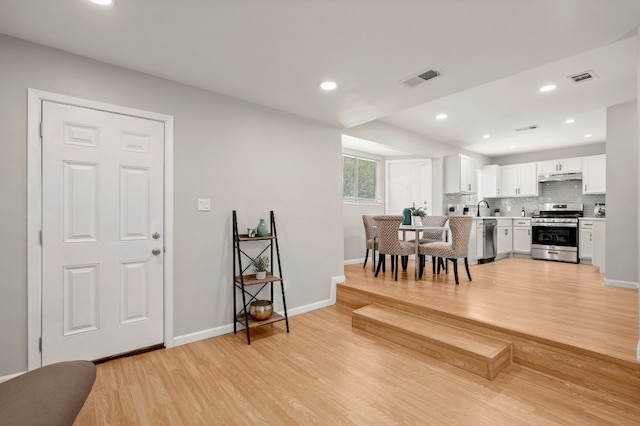 dining area with sink and light hardwood / wood-style floors