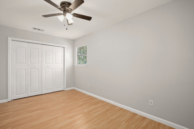 unfurnished bedroom featuring light hardwood / wood-style flooring, ceiling fan, and a closet