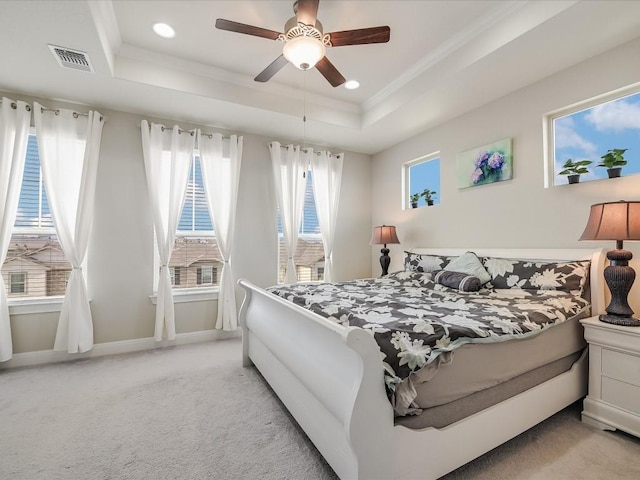 bedroom featuring visible vents, multiple windows, and a tray ceiling