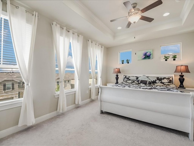 bedroom with a tray ceiling, light carpet, baseboards, and recessed lighting