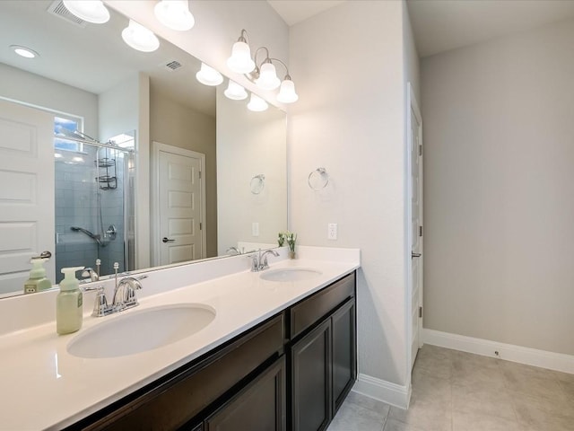 full bath with double vanity, a shower stall, baseboards, and a sink