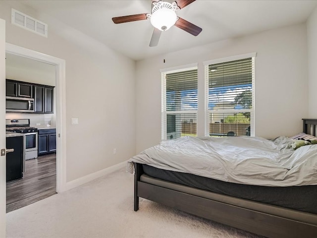 carpeted bedroom featuring a ceiling fan, visible vents, and baseboards