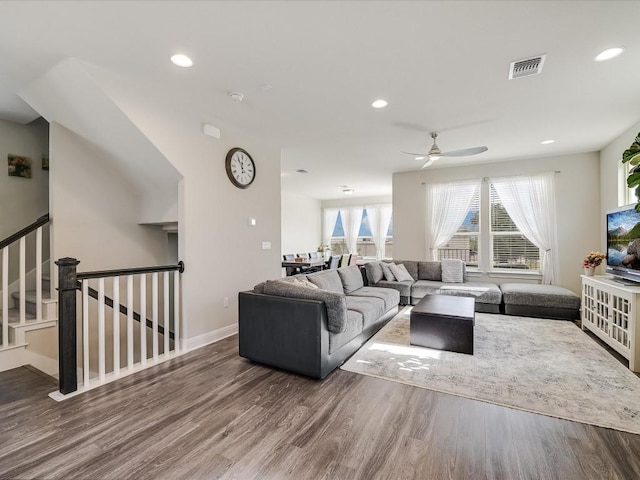 living area featuring recessed lighting, visible vents, wood finished floors, baseboards, and stairs