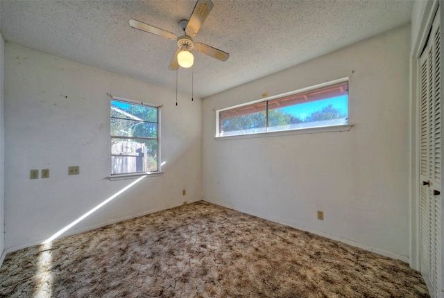 unfurnished bedroom featuring ceiling fan, a textured ceiling, a closet, and carpet flooring