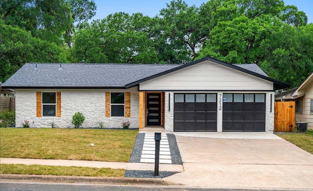 view of front facade with central AC unit, a front yard, and a garage