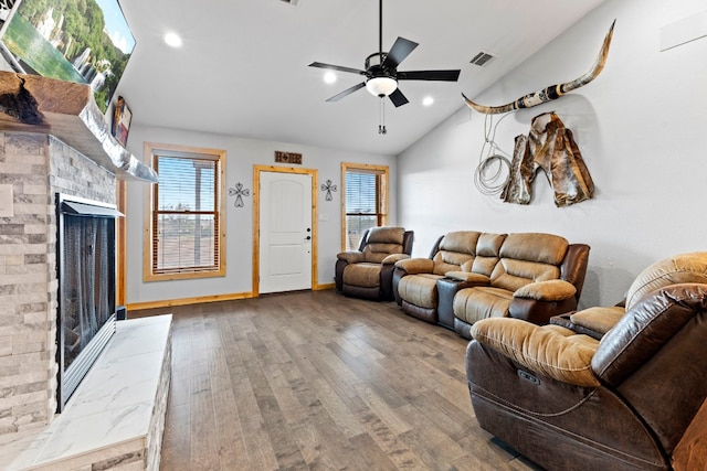 living room featuring ceiling fan, a wealth of natural light, wood-type flooring, and vaulted ceiling