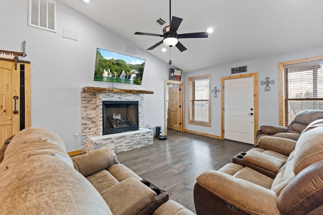 living room featuring a stone fireplace, a barn door, high vaulted ceiling, dark hardwood / wood-style floors, and ceiling fan