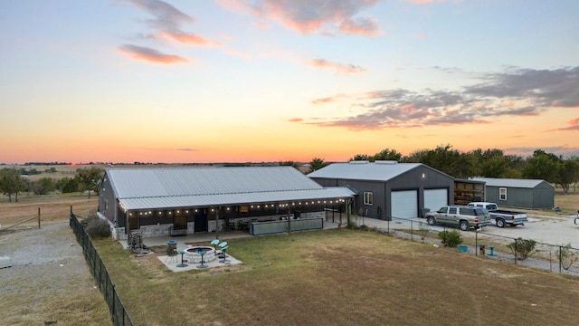 exterior space featuring a garage, a fire pit, an outbuilding, and a yard