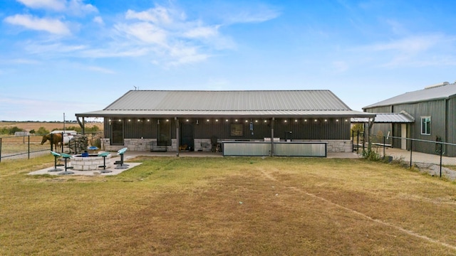 rear view of property with a patio area, a yard, and a fire pit