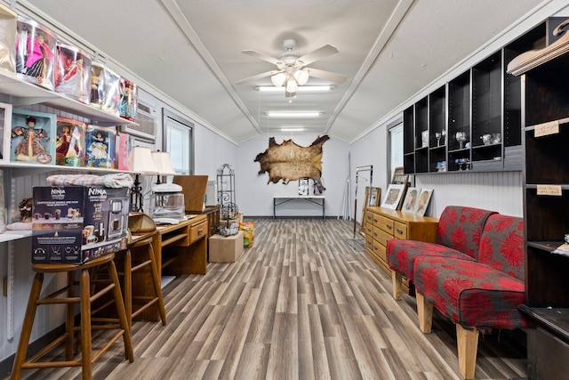 interior space featuring ceiling fan, wood-type flooring, lofted ceiling, and ornamental molding