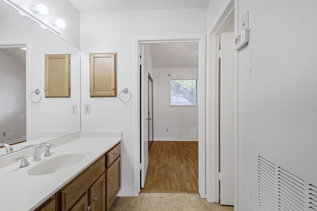 bathroom featuring vanity, tile patterned flooring, and a textured ceiling