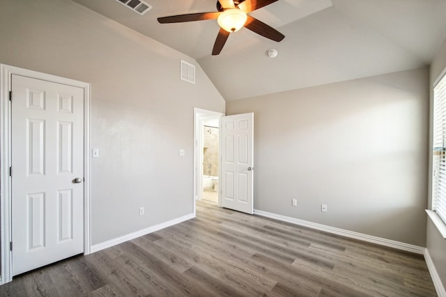 unfurnished bedroom with hardwood / wood-style flooring, ceiling fan, and vaulted ceiling