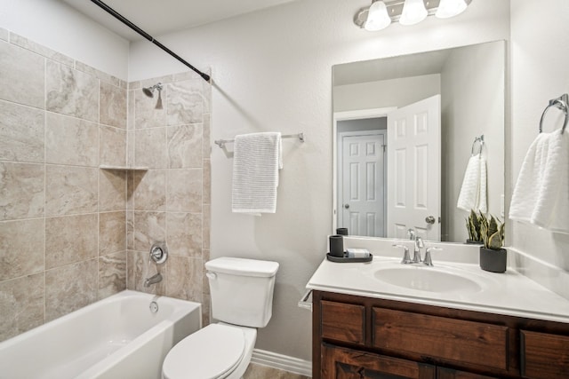 full bathroom featuring tiled shower / bath, vanity, and toilet