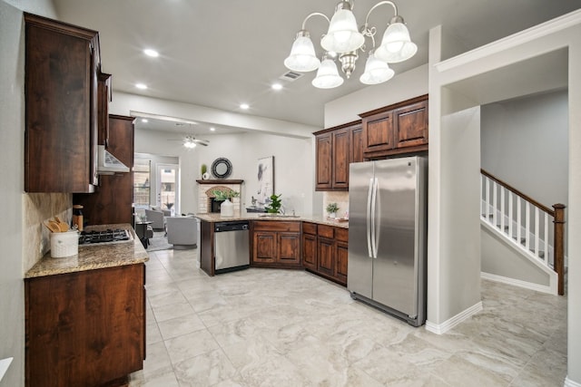 kitchen featuring tasteful backsplash, stainless steel appliances, light stone countertops, pendant lighting, and ceiling fan with notable chandelier