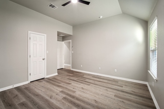 empty room with wood-type flooring, ceiling fan, and lofted ceiling