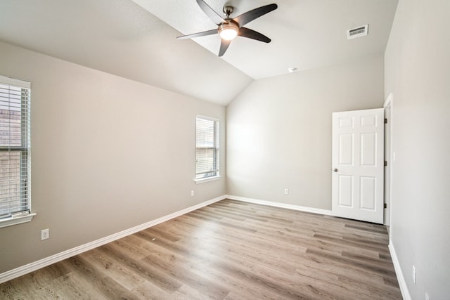 spare room featuring lofted ceiling, ceiling fan, and light hardwood / wood-style flooring