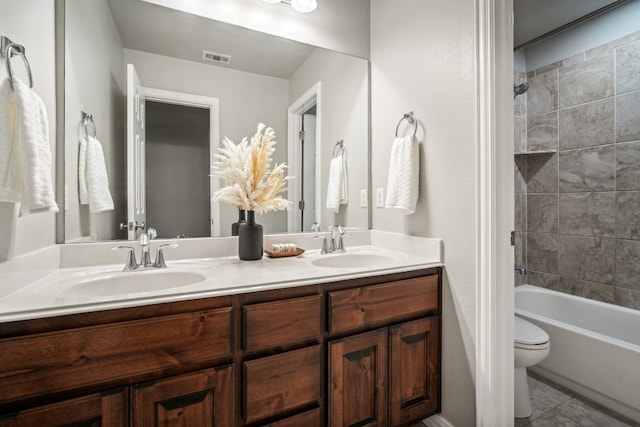 full bathroom with toilet, vanity, tiled shower / bath, and tile patterned floors