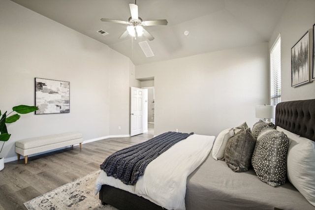 bedroom with hardwood / wood-style floors, ceiling fan, and vaulted ceiling