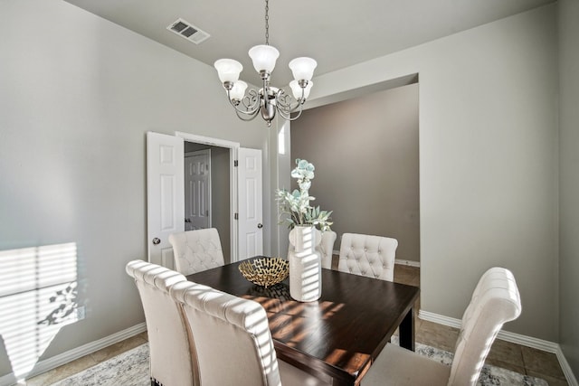 dining space featuring tile patterned flooring and a notable chandelier