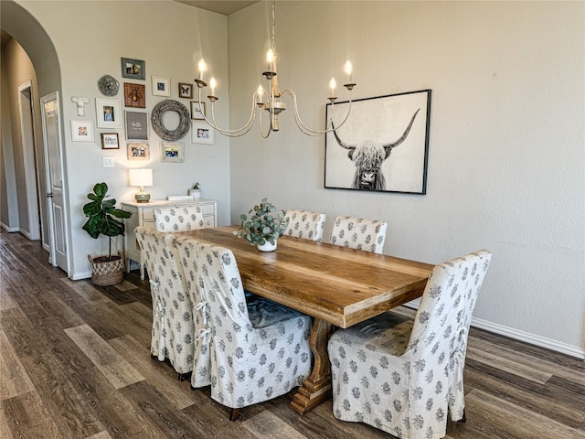 dining room with dark wood-type flooring and a chandelier