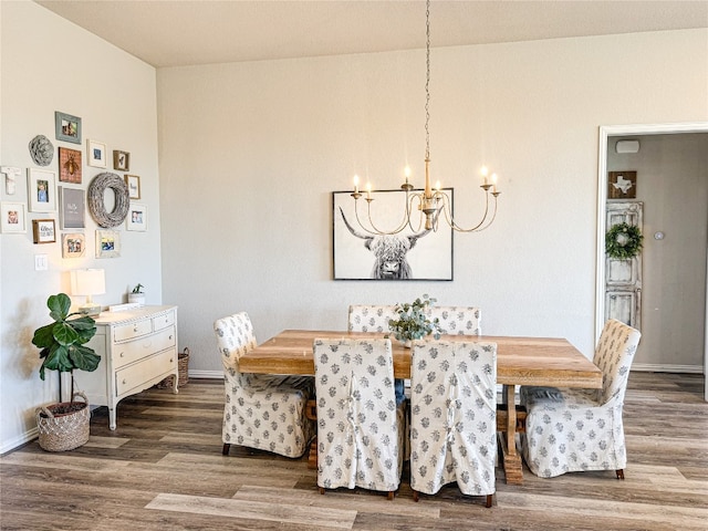 dining area with hardwood / wood-style floors and a chandelier