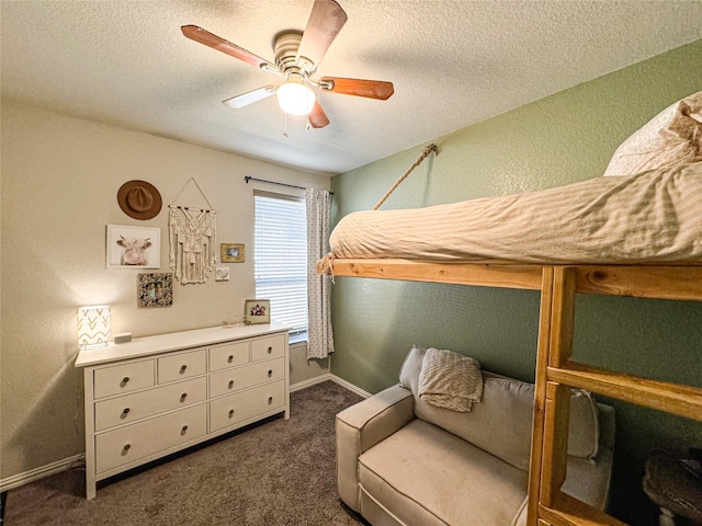 bedroom featuring a textured ceiling, dark colored carpet, and ceiling fan