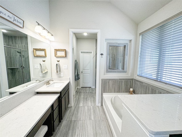 bathroom with walk in shower, vanity, and vaulted ceiling