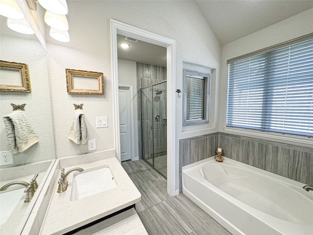 bathroom with vanity and shower with separate bathtub