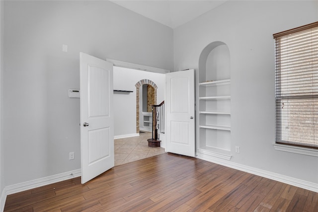 spare room with built in features and hardwood / wood-style flooring