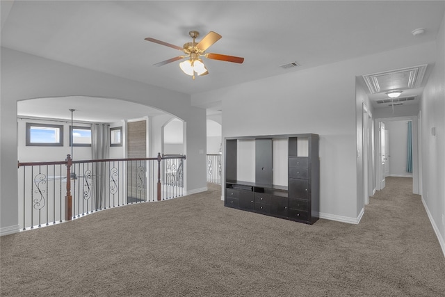 unfurnished living room with carpet and ceiling fan