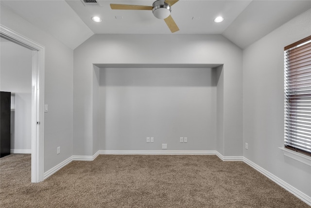 empty room with vaulted ceiling, ceiling fan, and carpet floors