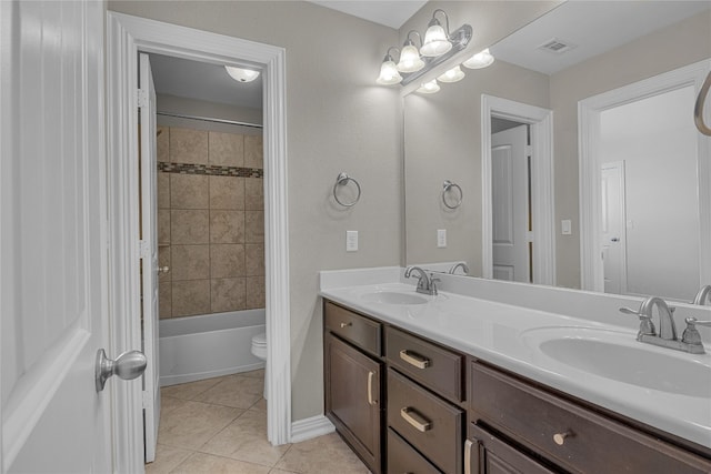 full bathroom with toilet, tiled shower / bath combo, vanity, and tile patterned floors