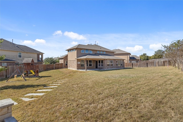 rear view of property with a lawn, a playground, and a patio