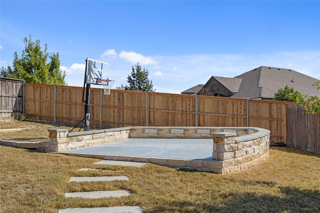 view of basketball court with a yard