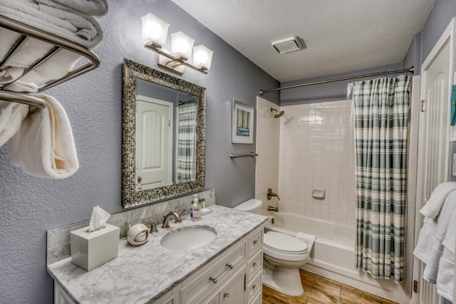 full bathroom featuring vanity, toilet, a textured ceiling, hardwood / wood-style floors, and shower / tub combo with curtain