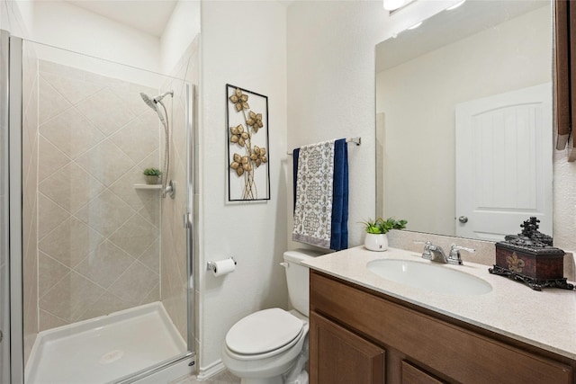 bathroom with an enclosed shower, vanity, and toilet