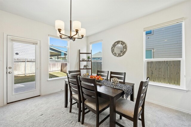 carpeted dining space featuring a chandelier