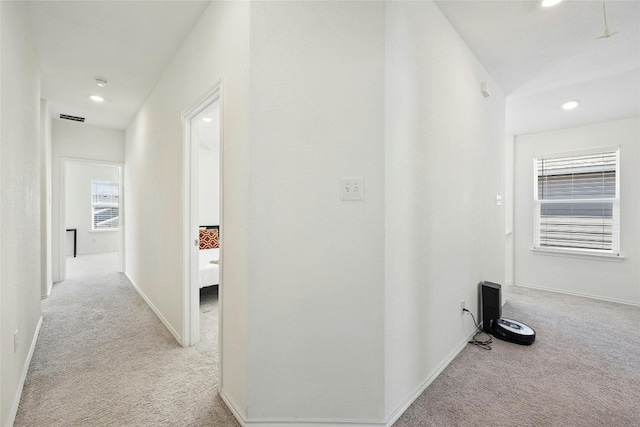 hallway featuring light colored carpet and a healthy amount of sunlight