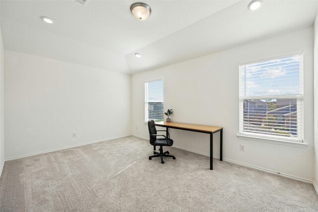 carpeted office with lofted ceiling