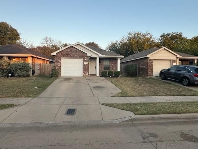 single story home featuring a garage and a front yard