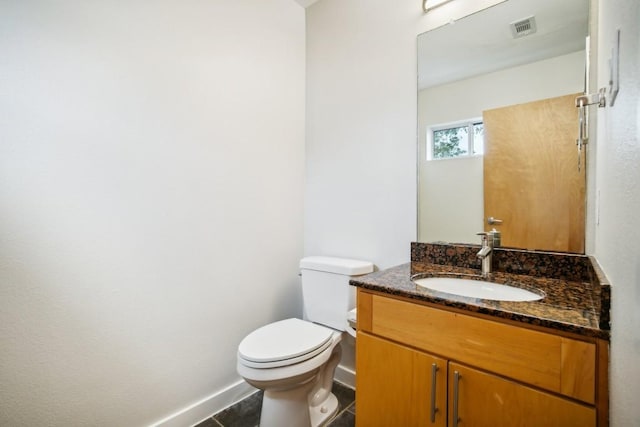 bathroom with tile patterned flooring, vanity, and toilet